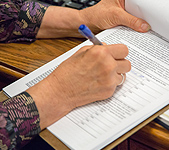 Woman's hands filling out a form on a clipboard